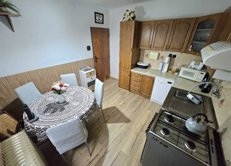 A kitchen in a family house with wooden decor and a dining table.