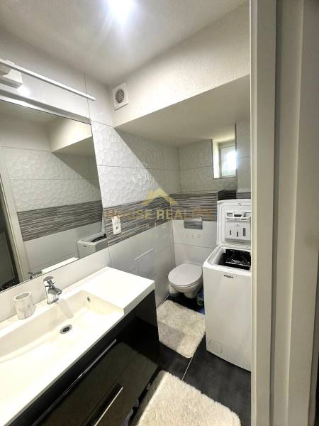 Bathroom in a 2-room apartment with a sink, washing machine, and toilet.