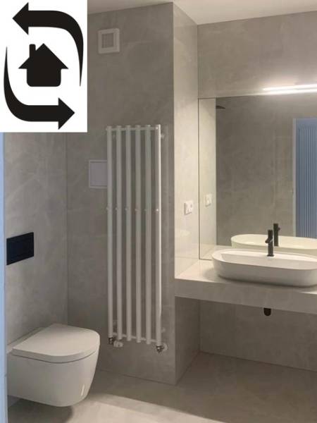Modern bathroom in a 2-room apartment with a mirror, sink, and toilet.