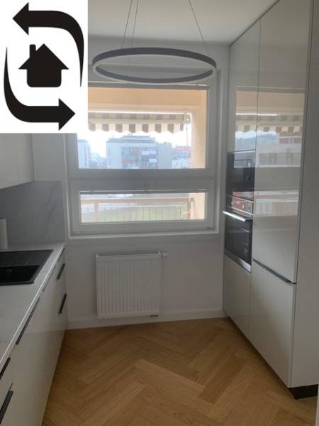A kitchen with a wooden decor floor in a 2-room apartment has modern appliances.