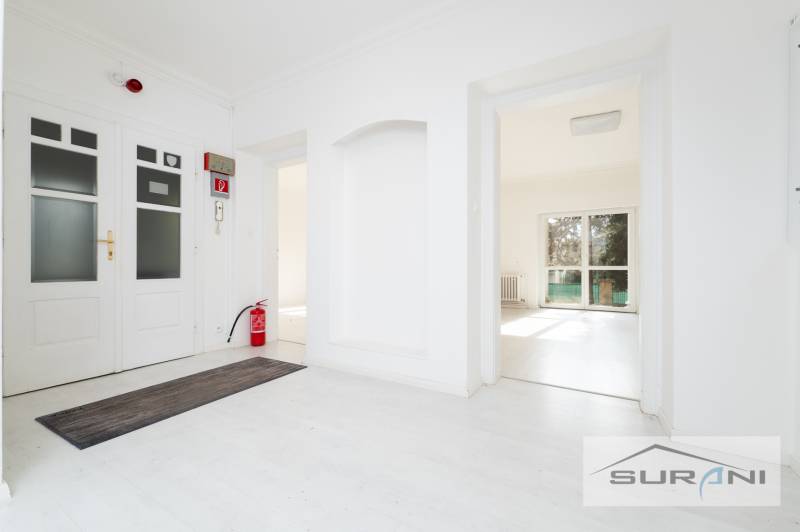 A bright interior of a 4-room apartment with a wooden decor floor and a fire extinguisher.