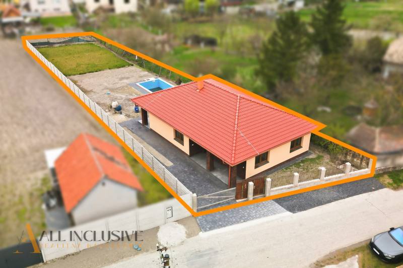 A family house in Horné Mýto with a red roof and a swimming pool in the yard.