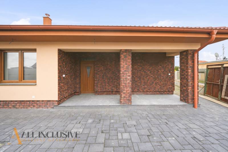A family house in Horné Mýto with a brick facade and a paved courtyard.