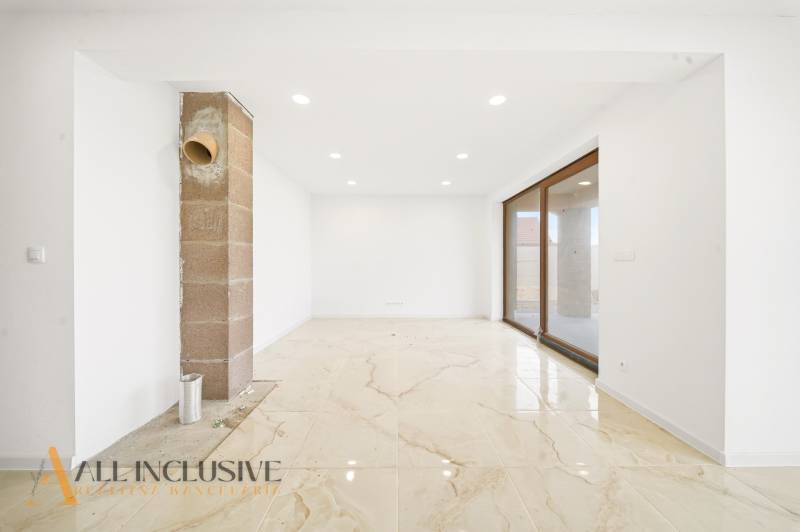 A spacious room in a family house with large windows and a light floor.