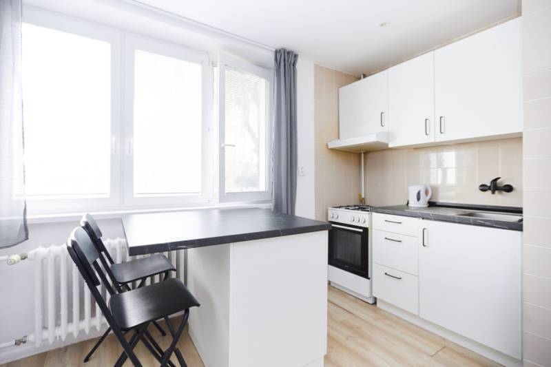 A kitchen in a 2-room apartment with a counter and a wooden decor floor.
