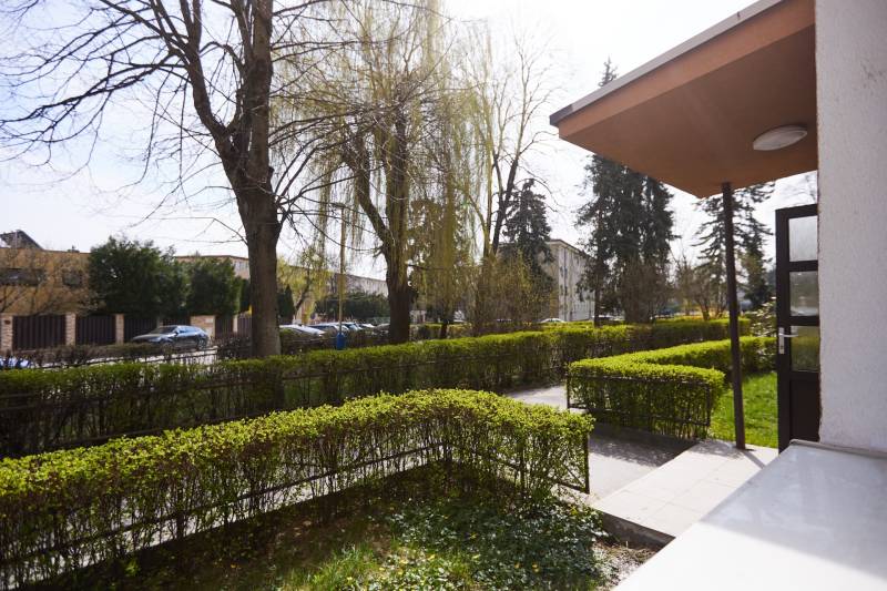 Garden with a walkway and parked cars on Lomnická Street in Košice, Sever district.