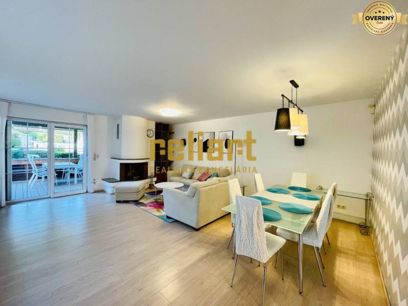 Interior of a family house with a fireplace, wooden decor flooring, and a dining table.