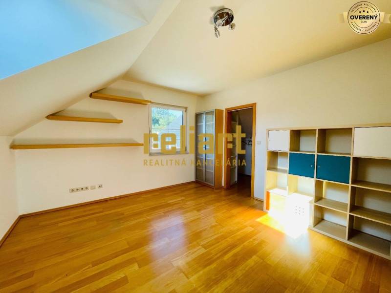 A room in a family house with a wooden decor floor, shelves, and a shelving cabinet.