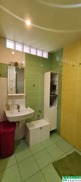 A bathroom with a sink, bathroom furniture, and colorful tiles in a 3-room apartment.