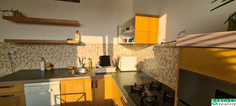 A kitchen in a 3-room apartment with wooden cabinets and mosaic tiles.