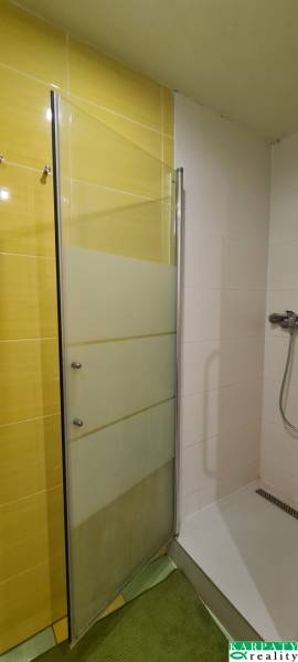 Shower enclosure with doors in a 3-room apartment, combination of yellow and white tiles.