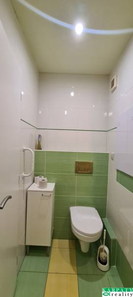 A bathroom in a 3-room apartment with green ceramic tiles and modern sanitary equipment.