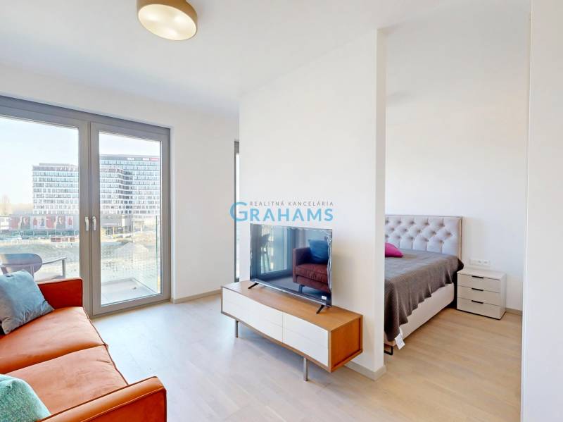 Living room and bedroom in a 2-room apartment with a wooden decor floor.