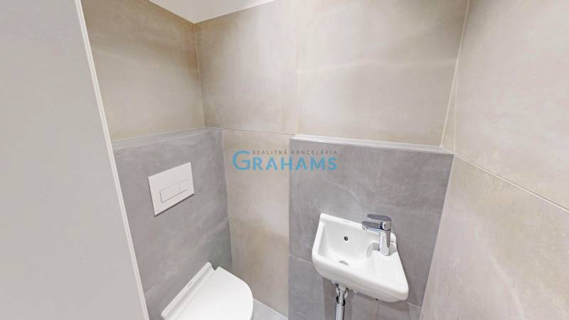 Bathroom with a toilet and sink in a 2-room apartment with a simple design.