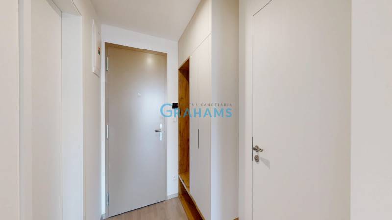Entrance hall in a 2-room apartment with wood-patterned flooring and storage space.