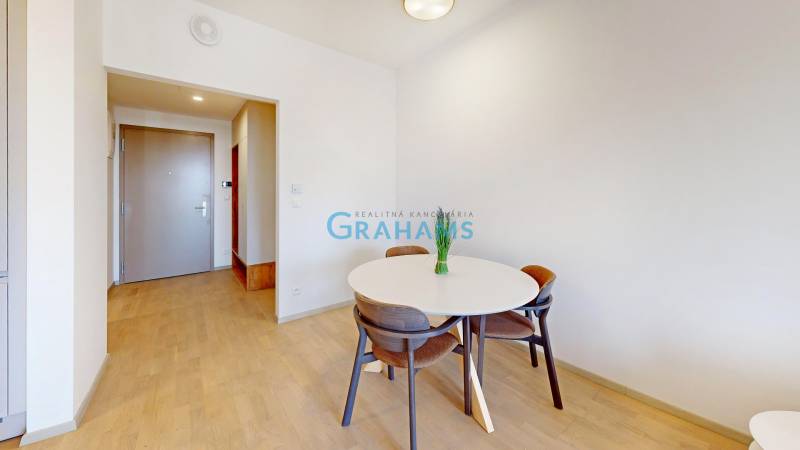 Interior of a 2-room apartment with a dining table and a floor with a wooden decor.