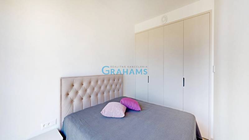 Bedroom in a 2-room apartment with a bed and a wardrobe.