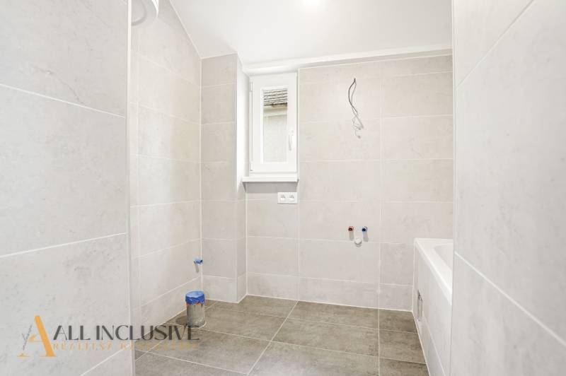 A bathroom in a family house with large-format light tiles.