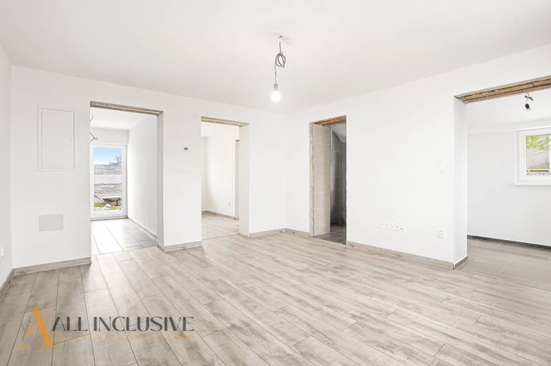 The interior of a family house with a wooden decor floor and clean white walls.