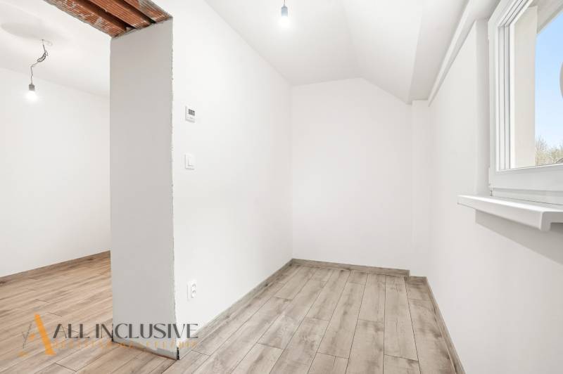White room with wood-patterned flooring in a family house.