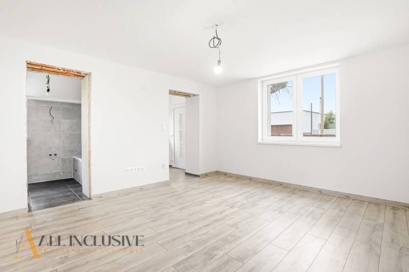 The interior of a family house with a wooden decor floor and a large window.