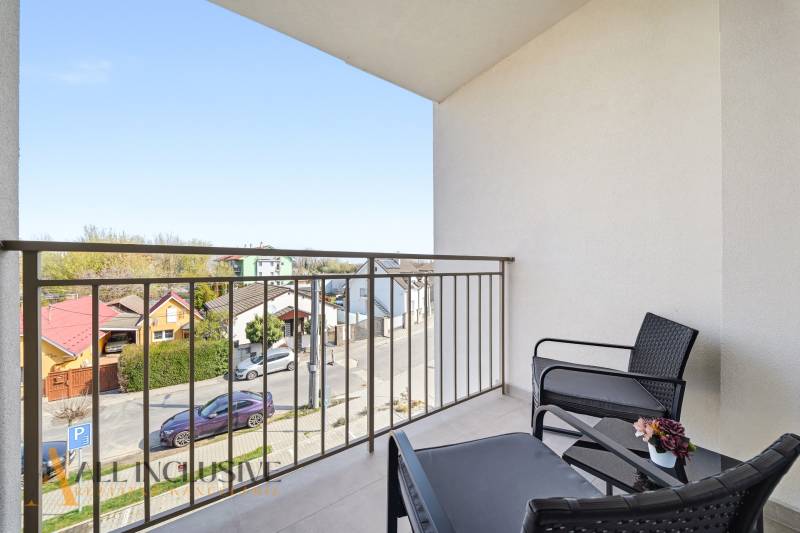 A balcony with seating and a view of the streets of a 4-room apartment in Dunajská Streda.