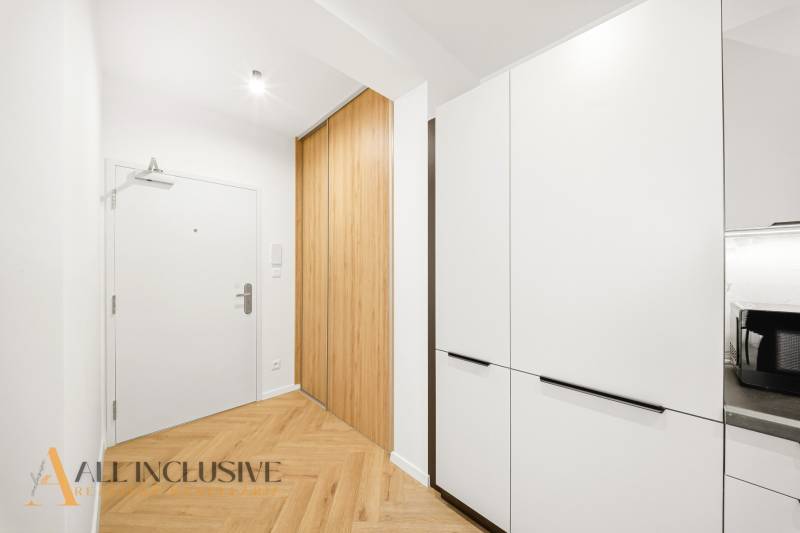 Entrance hallway in a 4-room apartment with wood-patterned flooring and built-in wardrobes.