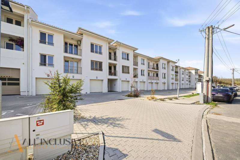 A set of white buildings and parking spaces in Dunajská Streda, ideal for a 4-room apartment.