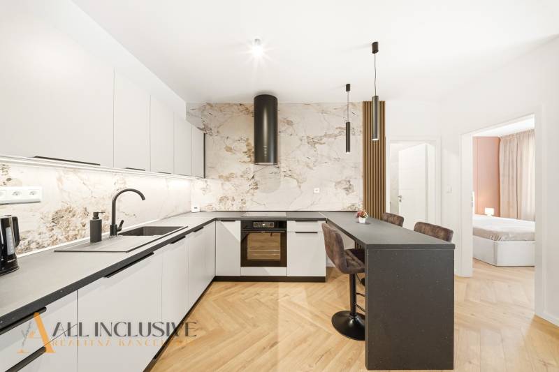A kitchen with a counter and a wooden decor floor in a 4-room apartment.