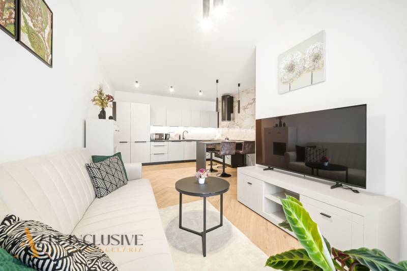 Living room with kitchen in a 4-room apartment with a wooden decor floor.