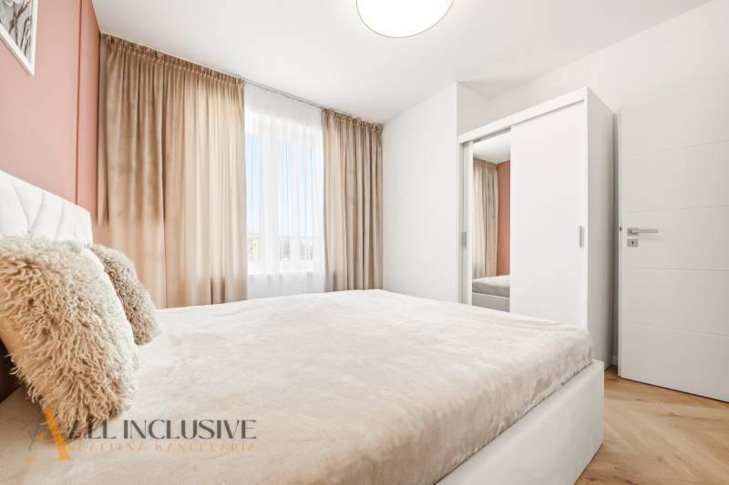 A bright bedroom in a 4-room apartment with a white wardrobe and curtains.