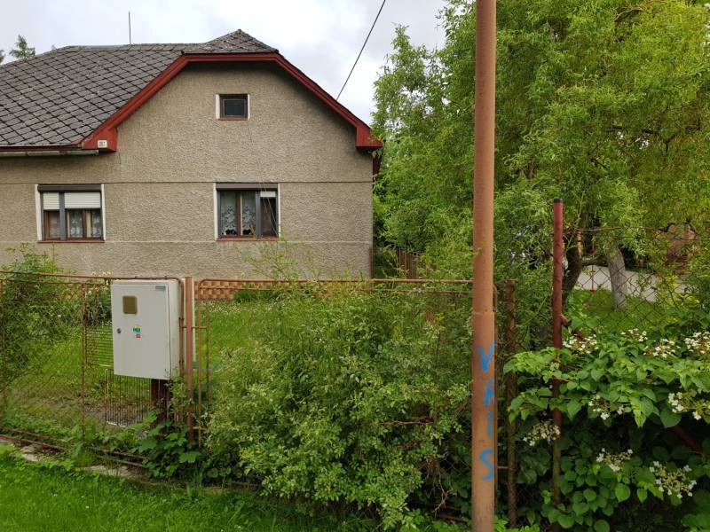 A family house in Blatnica on Blatnica Street surrounded by greenery and a fence.