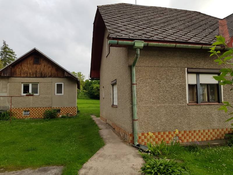 A family house in Blatnica on Blatnica Street with two buildings and a green lawn.