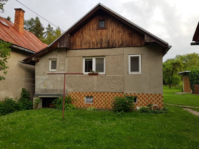 A family house on Blatnica Street in Blatnica with a lawn and wooden details.