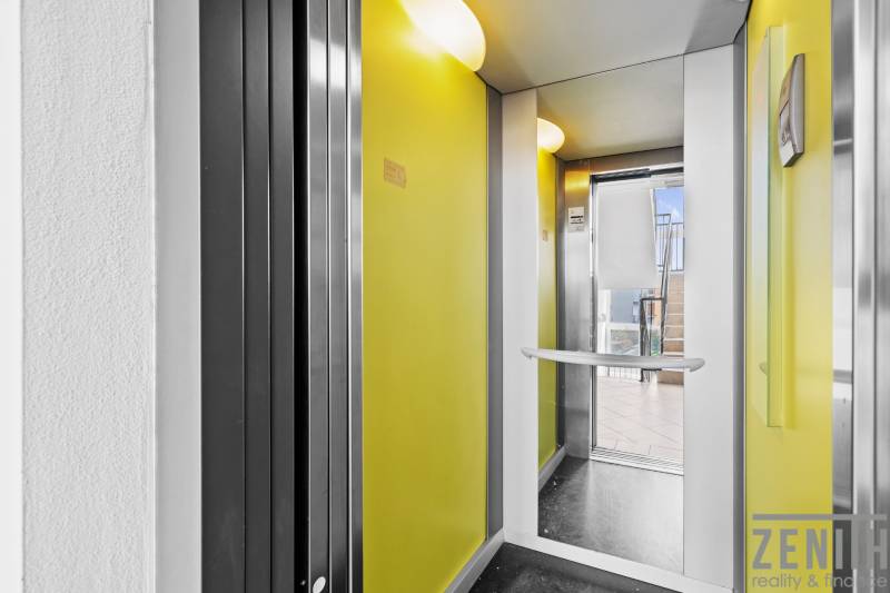 Yellow walls and glass doors of the elevator on M. R. Štefánik Street in Most pri Bratislave.