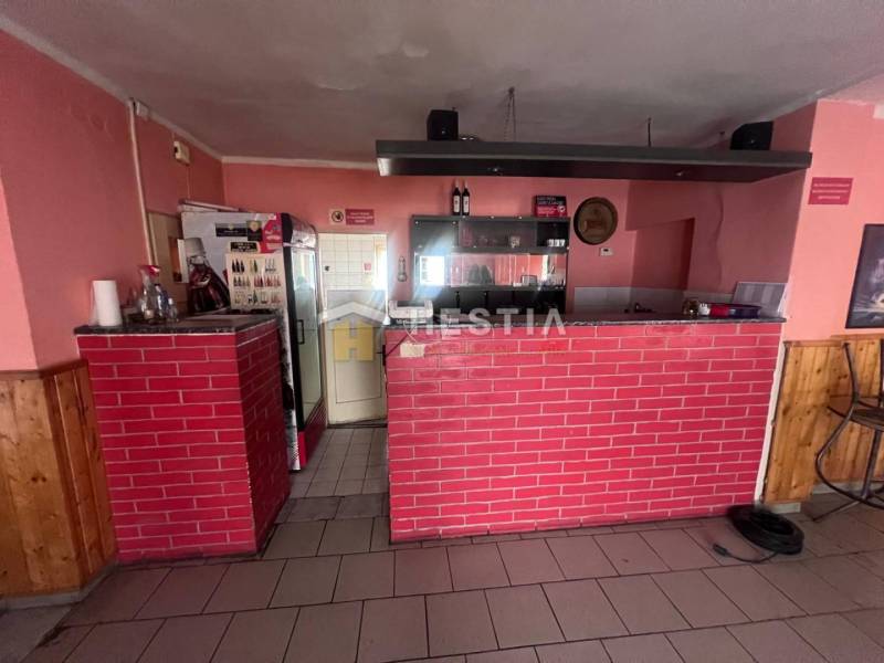 Gastro premises with a brick bar, wooden decor flooring, walls with pink paint.