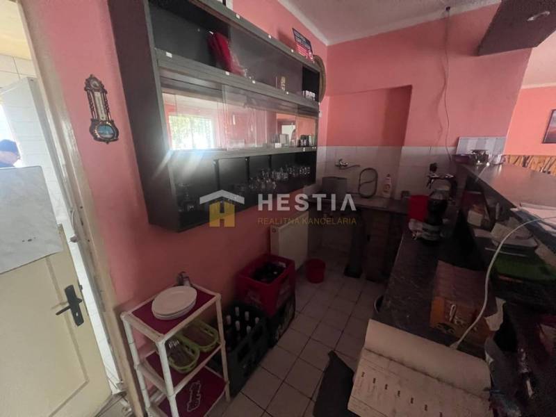 Kitchen corner in gastro premises with a counter, shelves, and equipment.