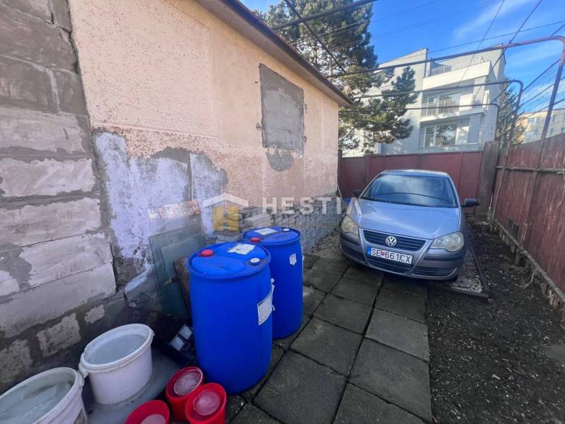 A car next to a building with barrels in the gastro area in Senica.