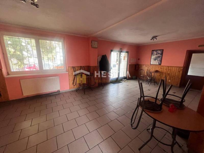 Gastro premises with a brick floor, wooden decor on the walls, and tables.