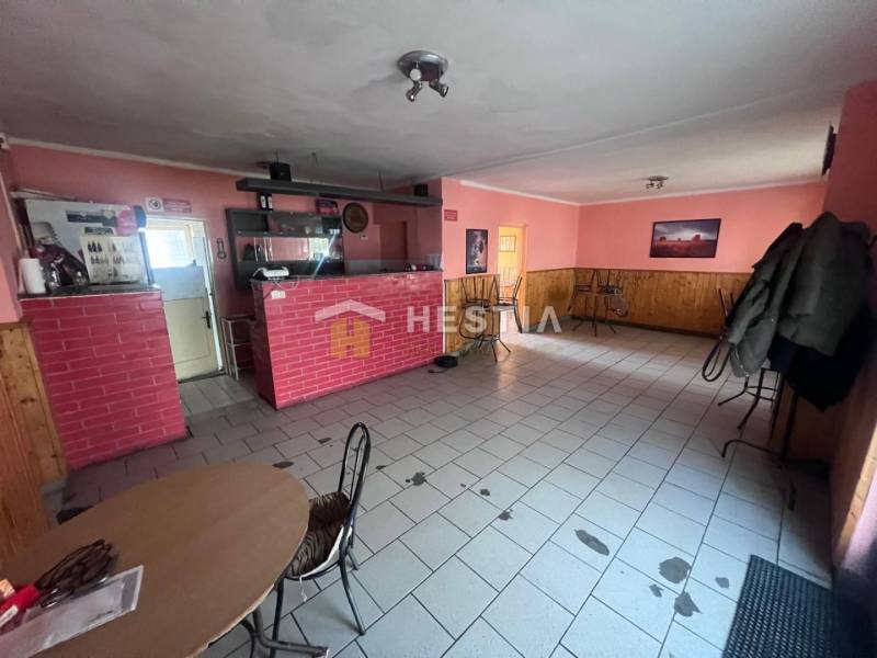 Interior of a gastro space with a red brick counter and pink walls.