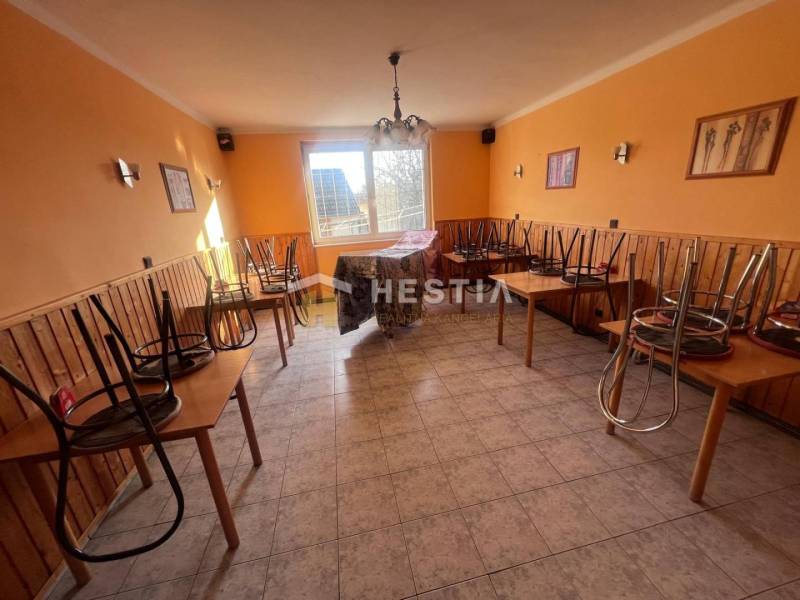 Gastro premises with tiles, chairs on tables, orange walls, and a window to the courtyard.