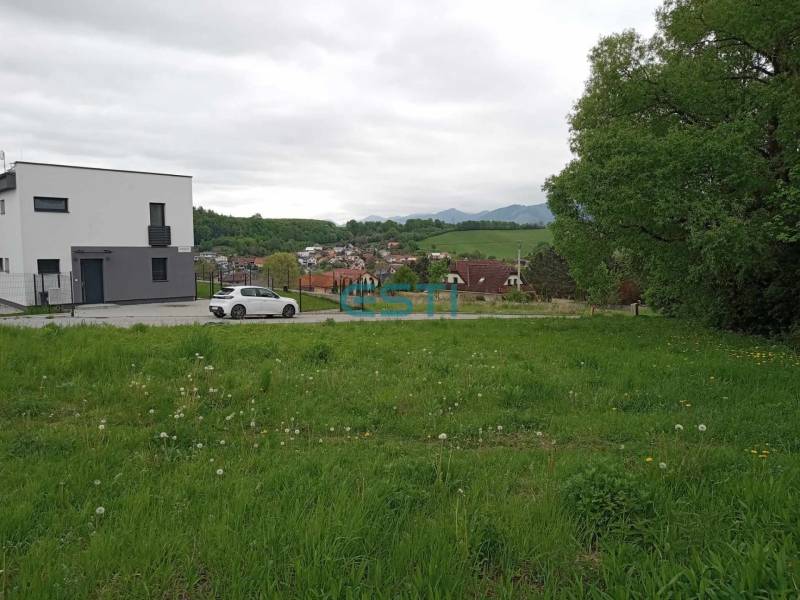 Plots - housing in Žilina on Chotárna show a green meadow with a modern building and a car.
