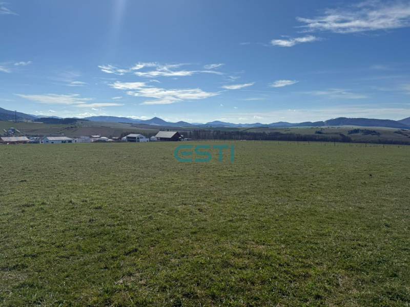 Plots - living in Stránske on Borie Street. A vast green meadow with a mountain backdrop.