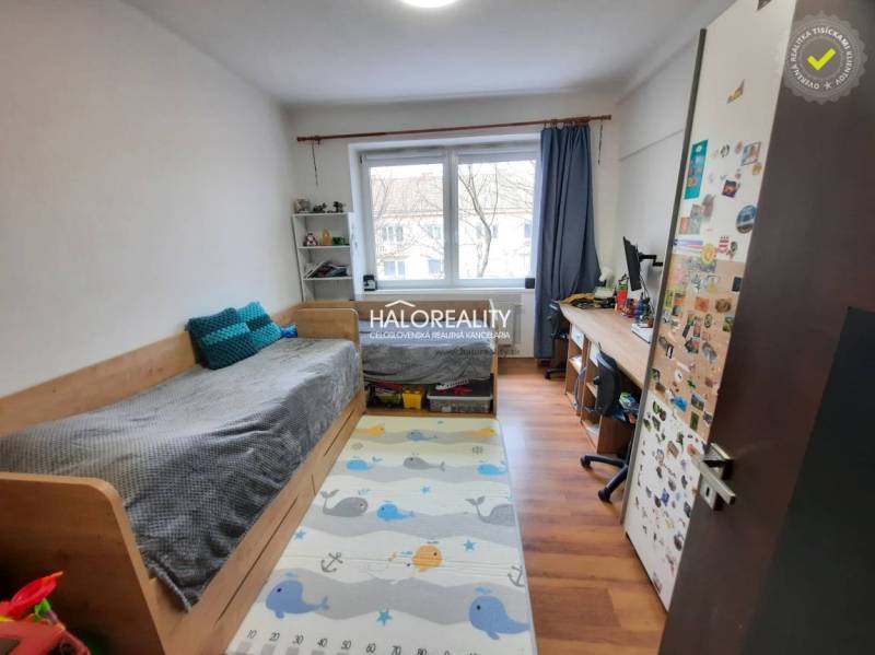 Children's room with a bed, desk, and floor with wooden decor in a 3-room apartment.