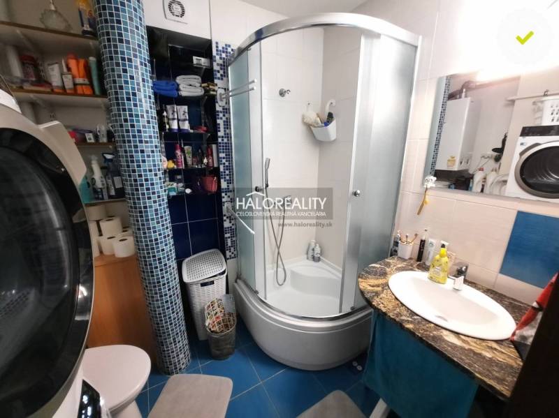 A bathroom in a 3-room apartment with a modern shower and a washing machine.