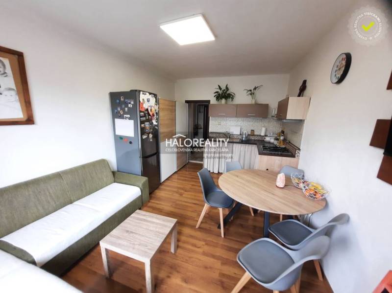 Living room with kitchen, wooden decor flooring, 3-room apartment, dining table and chairs.