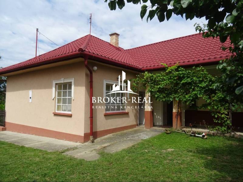 A family house in Goncruszka with a red roof and a green yard.