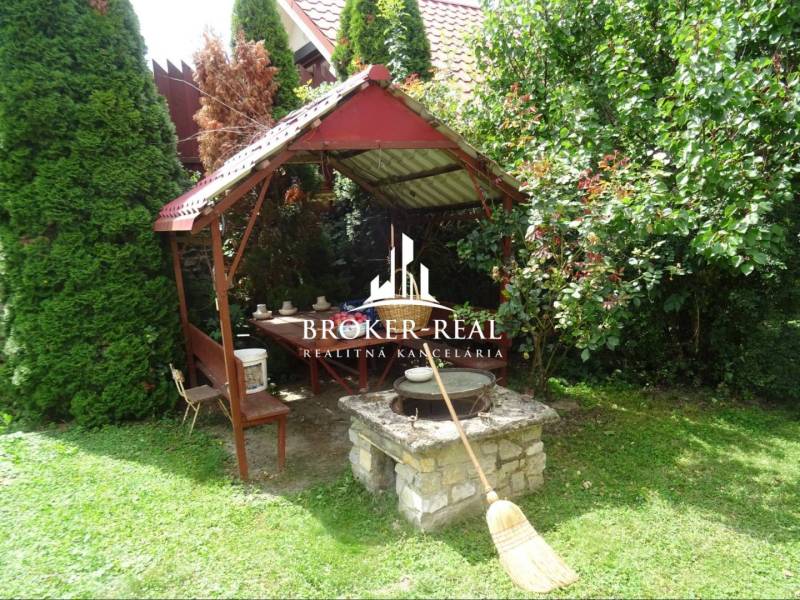 A gazebo with a table and benches in the garden by a family house in Goncruszka.