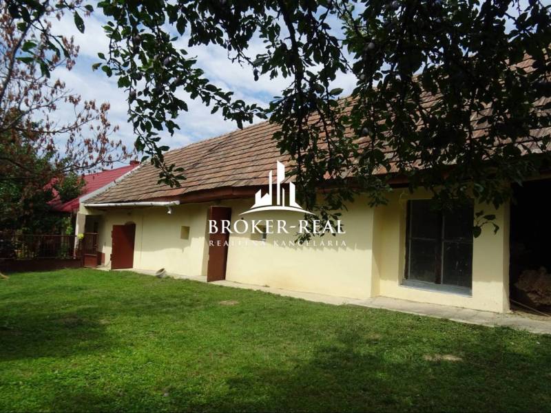 A family house in the town of Goncruszka with a garden and a traditional roof under a tree.