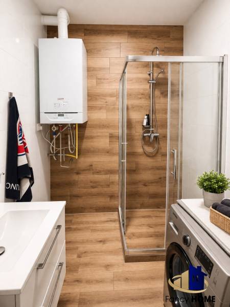 Bathroom in a 2-room apartment with a wooden decor floor and a shower corner.